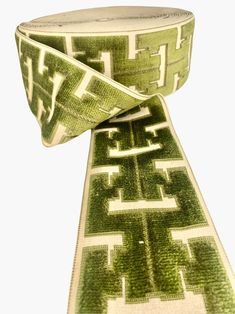 a green and white tie with an intricate design on the neckline is shown in front of a white background