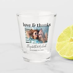 a shot glass next to a lemon on a white surface with the words save the date printed on it