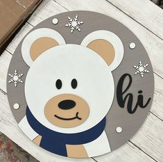 a wooden sign with a bear on it's face and snowflakes around its neck