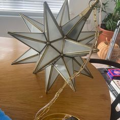 a glass star hanging from a chain on a table