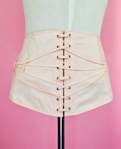 A lovely, classic pale pink fan laced girdle. The piece closes at the side with hook and eye closures and then is further secured with the laced fan and strap combination across the body. Nice firm structure with internal boning. Fabric content feels like cotton. Label is "Famous Gale" for Sears, Roebuck and Co. There is no size tag given. PLEASE see measurements below as I am not entirely sure how one sizes girdles! Apologies. Flat measurements are pictured. Dress form is modern Medium for refe Vintage Beige Underbust Corset, Pink Fitted Vintage Corset, Vintage Underbust Corset Belt With Boning, Hip Pads, Dress Form, 1950s Vintage, Pink Cotton, Pale Pink, Lace