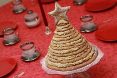 a christmas tree made out of cookies sitting on top of a table with red plates and silverware