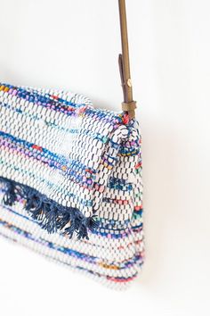 a white and blue purse hanging from a hook