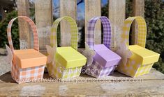 four small boxes sitting on top of a wooden table next to each other in different colors