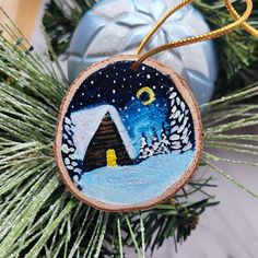 a christmas ornament hanging from a pine tree