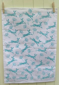 a teal and white wall hanging with deers on it's back side