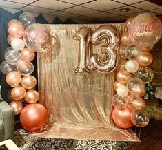 an arrangement of balloons and streamers with the number thirteen on it