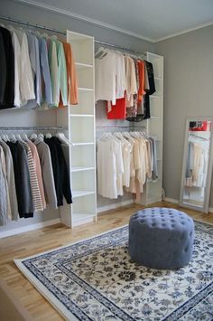 an organized closet with clothes and rug on the floor in front of it, along with a footstool