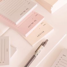 a pen sitting on top of a table next to some papers and sticky notes with words written on them