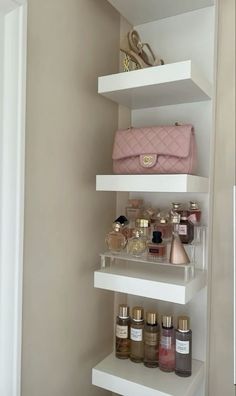 a white shelf filled with lots of different types of cosmetics and perfume bottles on top of it