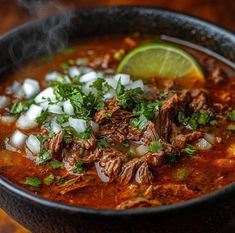 a bowl of soup with meat, onions and cilantro