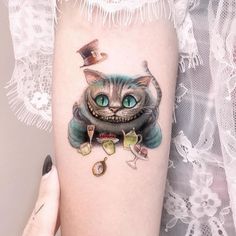 a woman's arm with a tattoo on it that has a cat wearing a top hat