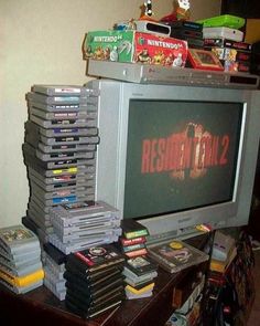 a bunch of video games stacked on top of each other in front of a television