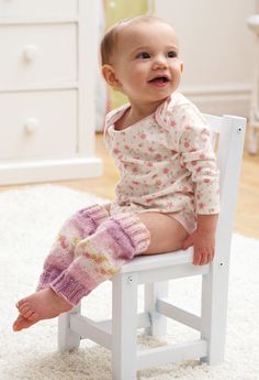 a baby is sitting on a white chair