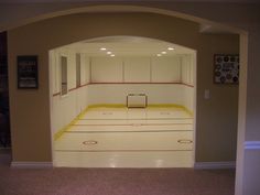 an empty room with yellow lines painted on the floor and white cabinets in the wall