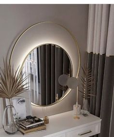 a white dresser topped with a mirror next to a window covered in curtains and plants