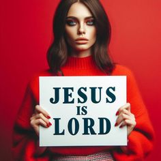 a woman holding a sign that says jesus is lord in front of her face, against a red background