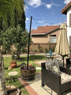 an outdoor patio with chairs, umbrella and potted plants