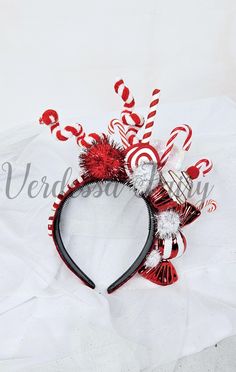 a red and white headband with candy canes on it's side,