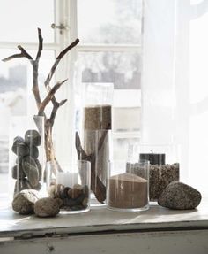 some rocks and plants are sitting on a window sill in front of a window