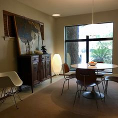 a dining room table and chairs in front of a large window