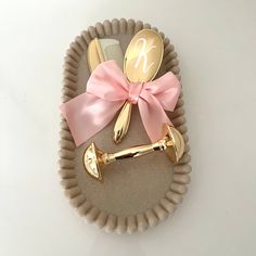 a paper plate with gold utensils and a pink bow