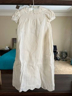 "This Christening gown has two pieces. One is the gown and the other one is the slip for inside the gown. It has lace on the collar, sleeves, and bottom of the gown. Trims with pin tucks down on the back. Embroidery on the front, and the bottom of the gown. Three buttons on the back and two buttons on top of the slip. The tag on the dress says Hand Made. Not exactly what size this dress is. It measures 26\" long and 12\" wide. 8-1/2\" chest across. Not sure when it was made. Handkerchief linen fabric. Hanger not included. Condition: There's one 1/4\" spot on top next to the button (back of the dress) and two small spots (1/8\" and 1/16\") on middle left back of the dress. No tears or rips. It is in very good condition as shown in the photo. Seller Notes: I include photos of each item, so y Elegant Baptism Dress With Lace Trim For Daywear, Elegant Baptism Dress With Lace Trim, Cream Baptism Dress With Lace Collar, Fitted Baptism Dress With Lace Trim, Fitted Baptism Dress With Lace Trim For Daywear, Cream Dress With Lace Bodice For Daywear, Baby Christening Gowns, Fabric Hanger, Vintage Baby Dresses