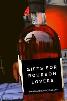 a bottle of liquor sitting on top of a table next to a sign that says gifts for bourbon lovers