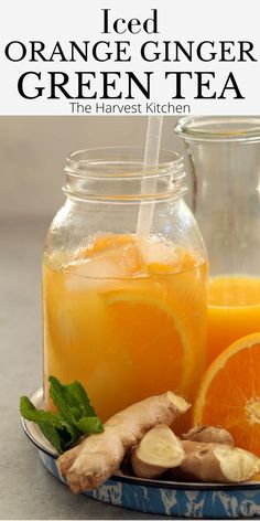 an orange ginger green tea in a glass jar with sliced oranges and ginger on the side