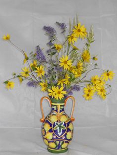 a vase filled with yellow and purple flowers