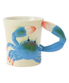 a blue and white ceramic mug with a crab on it's side, in front of a white background