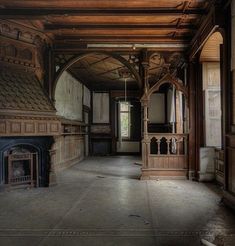 an empty room with wood paneling and a fire place in the center is shown