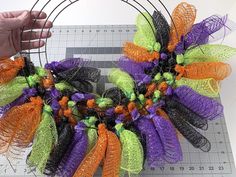 someone is making a halloween wreath out of mesh