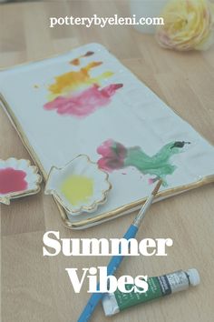 a wooden table topped with paint and flowers