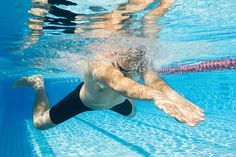 a man swimming under water in a pool