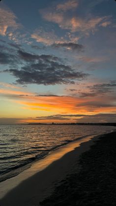 the sun is setting over the water at the beach