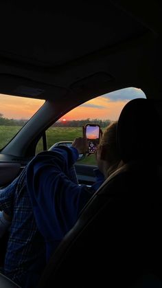 a person taking a photo in the back seat of a car with their cell phone