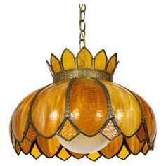 a light fixture hanging from a chain on a white background, with an orange and yellow shade