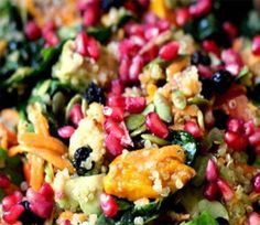 a colorful salad with carrots, spinach and other veggies in it