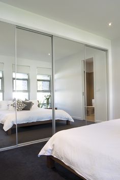 a bedroom with mirrored closet doors and a bed