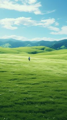 a person walking across a lush green field under a blue sky with fluffy white clouds