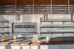 a bar with lots of bottles and glasses sitting on it's counter top next to shelves