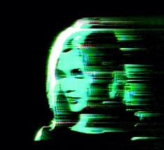 a blurry image of a woman's face in the dark with green light