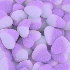 purple and white marshmallows are piled on top of each other