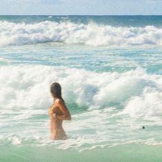 a woman is standing in the ocean water