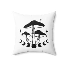 a black and white pillow with mushrooms in the middle, stars and crescents around it