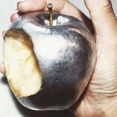 a person holding an apple with a bite taken out of it