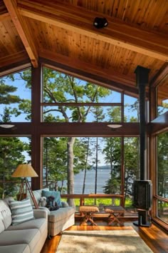 a living room filled with furniture next to a large window covered in lots of windows