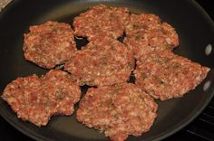 hamburger patties cooking in a frying pan on the stove