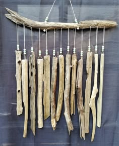 driftwood is hanging on the wall with beads